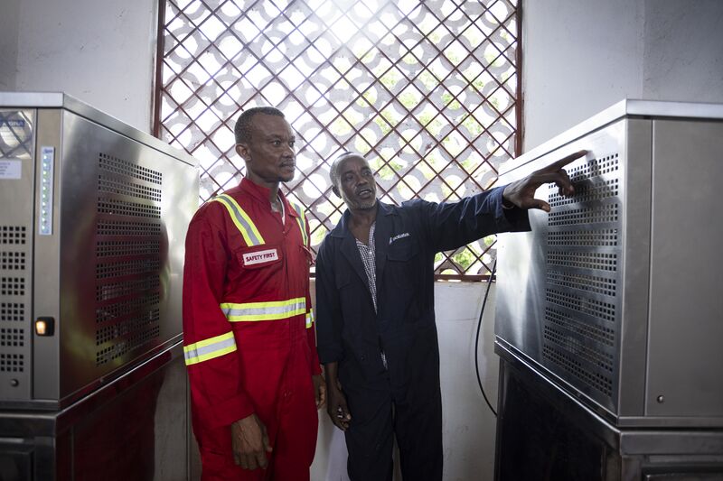 G3 2142 Kenneth Nyambu(right) lead technician at the Takaungu Solar Ice plant trains attendant Said Mkali on the machine operations manual on 30th June 2025 United Pictures Ltd & WWF Kenya.jpg