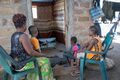 Sauda Meli watches television with her children at her home in Kalobeyei Village 1. The advent of the mini grid has enabled households in the area to access lighting and power at affordable rates.